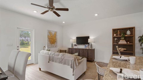 A living room with a white couch and a ceiling fan.