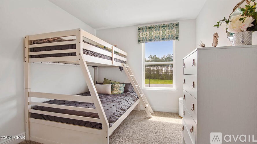 A bedroom with a bunk bed and a dresser.