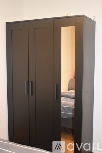 A bedroom with a bed and a wardrobe.