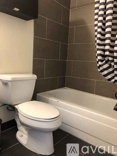 A white toilet is next to a bathtub in a bathroom.