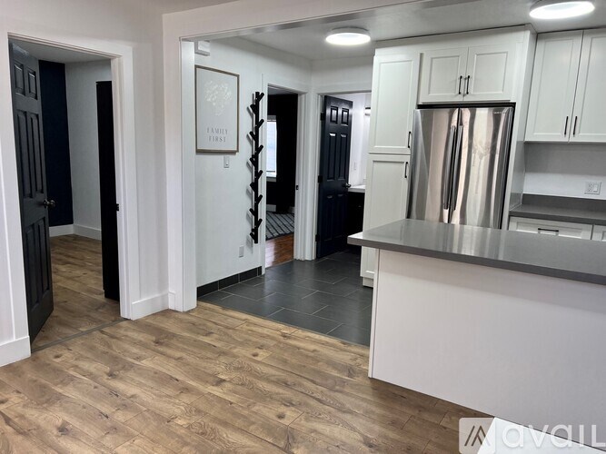 A kitchen with white cabinets and a stainless steel refrigerator.