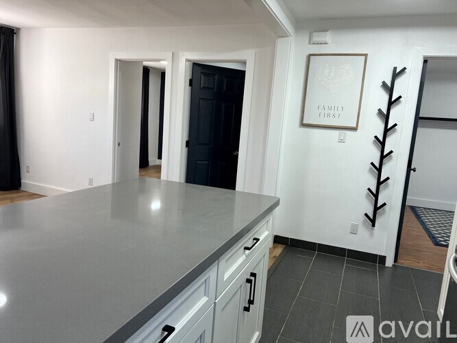 A kitchen with a grey countertop and a framed picture on the wall.