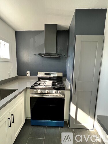 A modern kitchen with a stove and a hood.