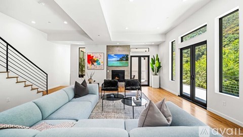 A living room with a grey couch and a black coffee table.