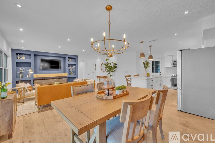 A modern kitchen with a dining table and chairs in the foreground.