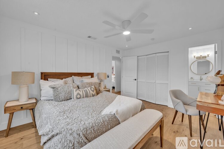 A bedroom with a large bed and a ceiling fan.