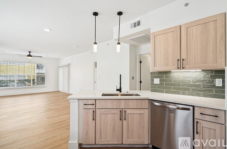 A kitchen with wooden cabinets and a stainless steel dishwasher.