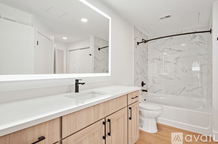 A bathroom with a marble wall and a white sink.