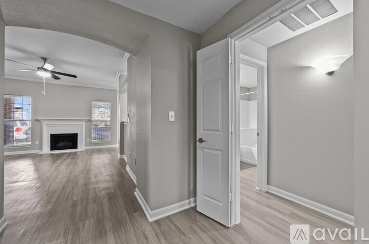 A room with a fireplace and a door leading to another room.