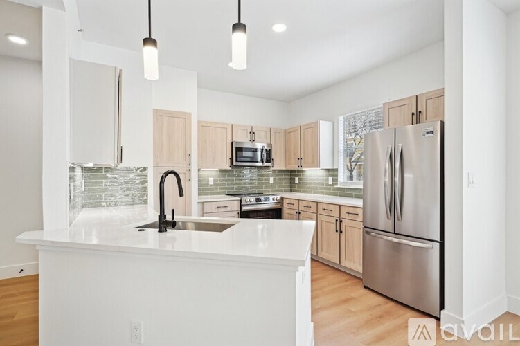 A kitchen with a white counter top and stainless steel appliances.