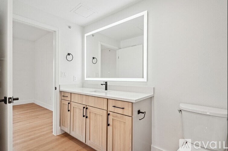 A bathroom with a sink, mirror, and cabinets.