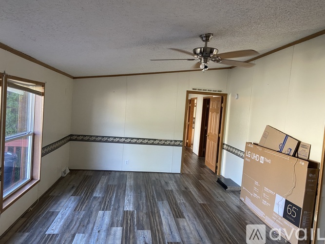 A room with a ceiling fan and a box labeled 65.