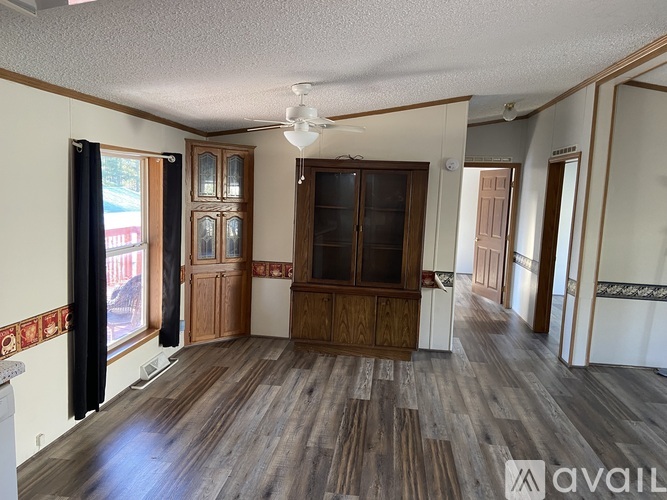A room with wooden floors and a large wooden cabinet.