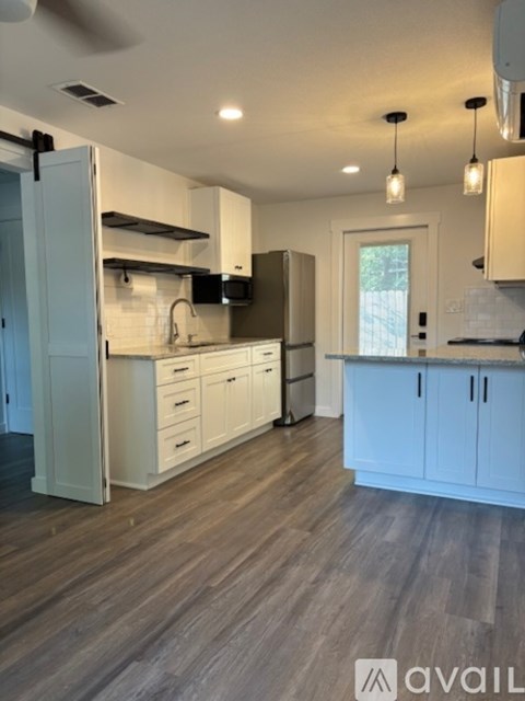 A kitchen with white cabinets and a window.