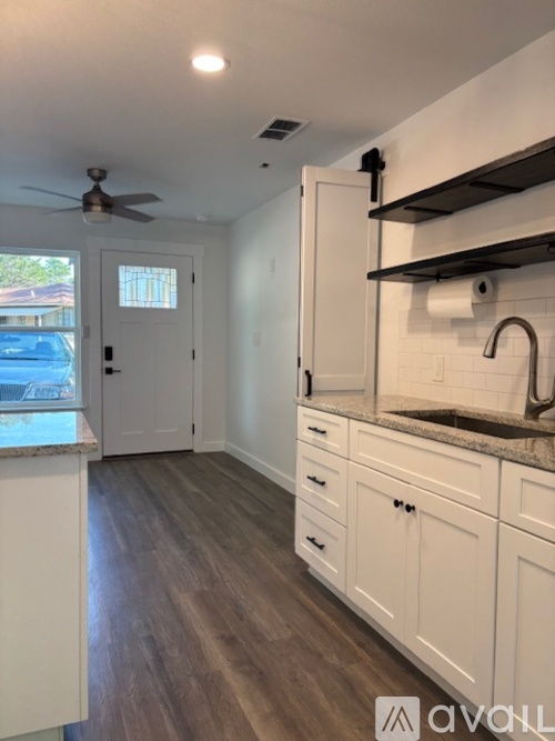 A kitchen with white cabinets and a stainless steel dishwasher and stove.