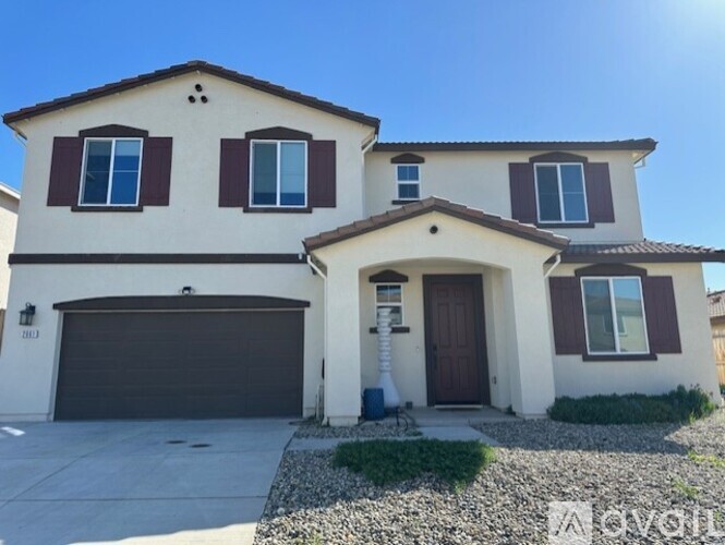 A two-story house with a garage and a brown door.