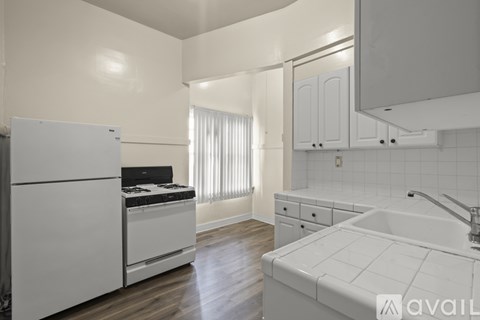 A kitchen with white appliances and cabinets.