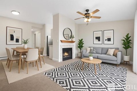 A living room with a fireplace, a grey couch, a coffee table, and a rug.