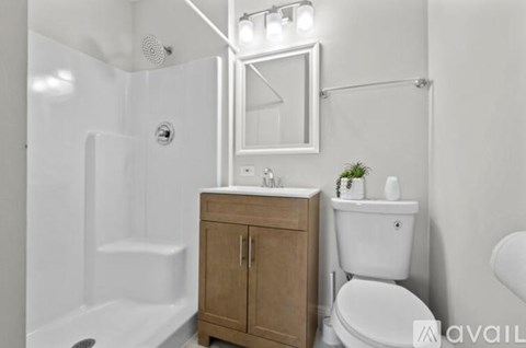 A bathroom with a white toilet, a white sink, a wooden cabinet, and a white bathtub.