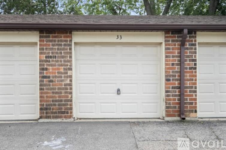 Two garage doors are closed and numbered 33.