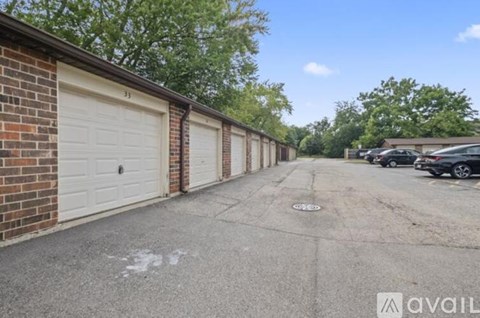 A long row of garage doors are on the left and a driveway is in the middle of the image.
