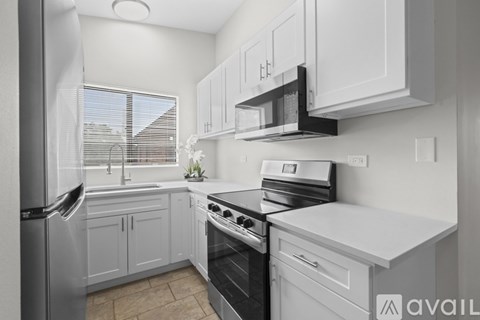A kitchen with white cabinets and appliances.