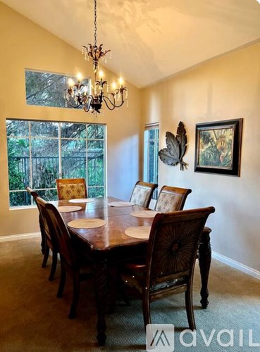 A dining room with a wooden table and chairs.