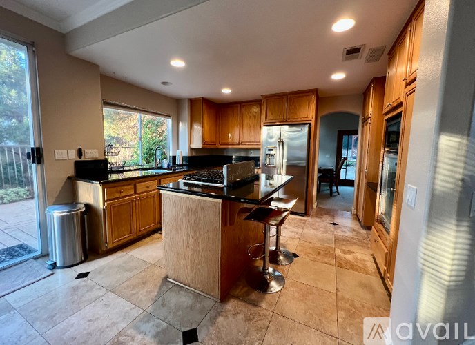 A kitchen with a bar stool in the middle of the room.