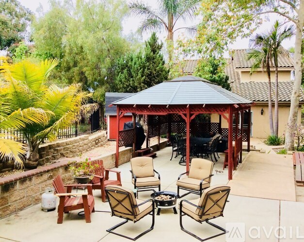 A patio with a gazebo and chairs.