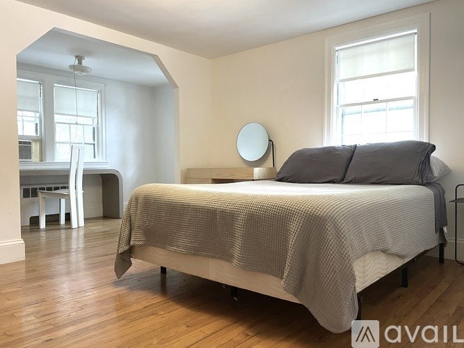 A bedroom with a bed, a desk, and a chair.