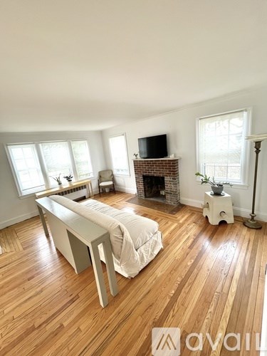 A living room with a white couch and a fireplace.