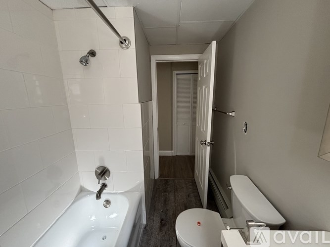 A bathroom with a white tub and toilet.