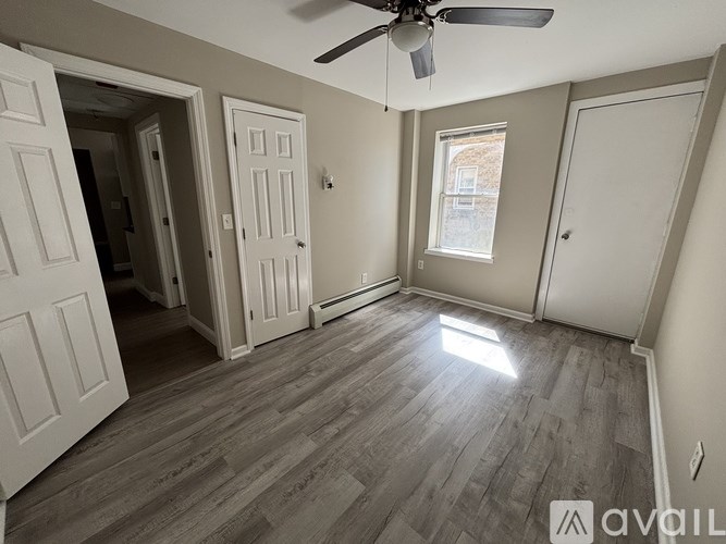 A room with a ceiling fan and wooden flooring.