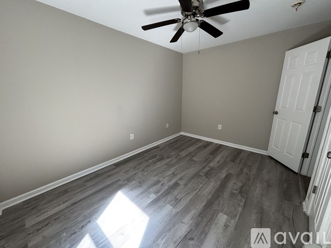 A room with a ceiling fan and a door.