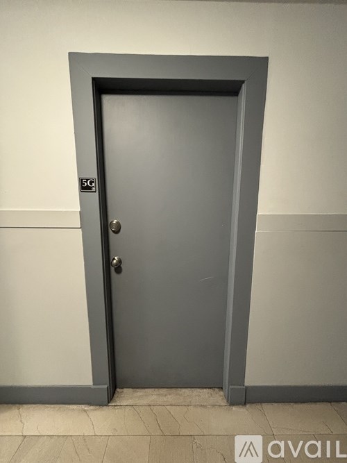A grey door with a silver handle and a 5G sticker on it.