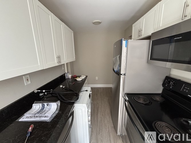 A kitchen with black countertops and white cabinets.