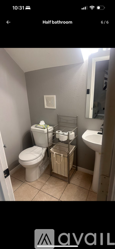 A bathroom with a toilet, sink, and towel rack.