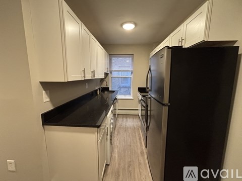 A kitchen with black countertops and white cabinets.