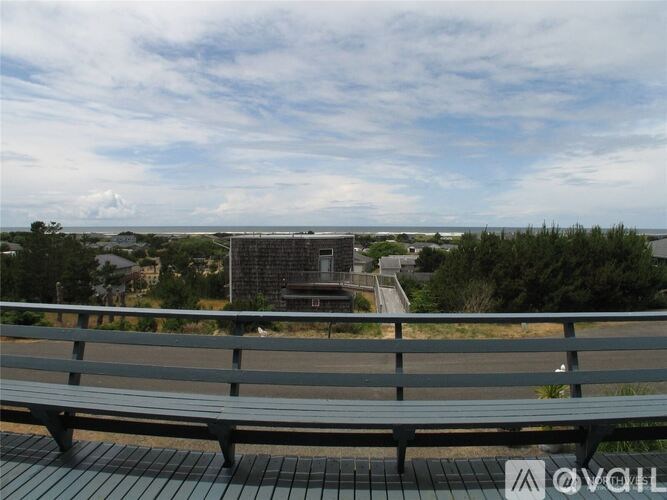 A bench with a view of a bridge and trees.
