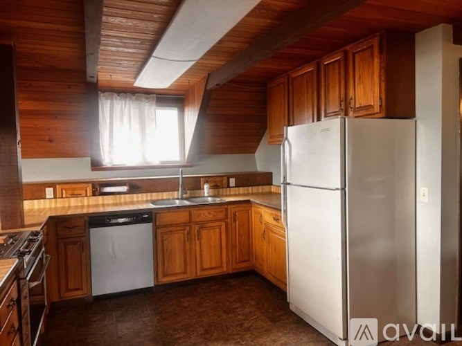 A kitchen with wooden cabinets and a white refrigerator.