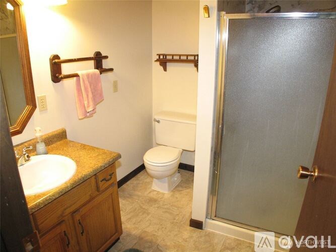 A bathroom with a toilet, sink, and a door.