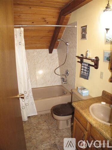 A bathroom with a toilet, sink, and shower.