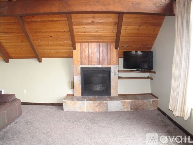 A living room with a fireplace and a television on a stand.