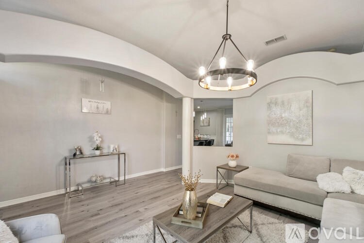 A modern living room with a grey sofa and a wooden coffee table.