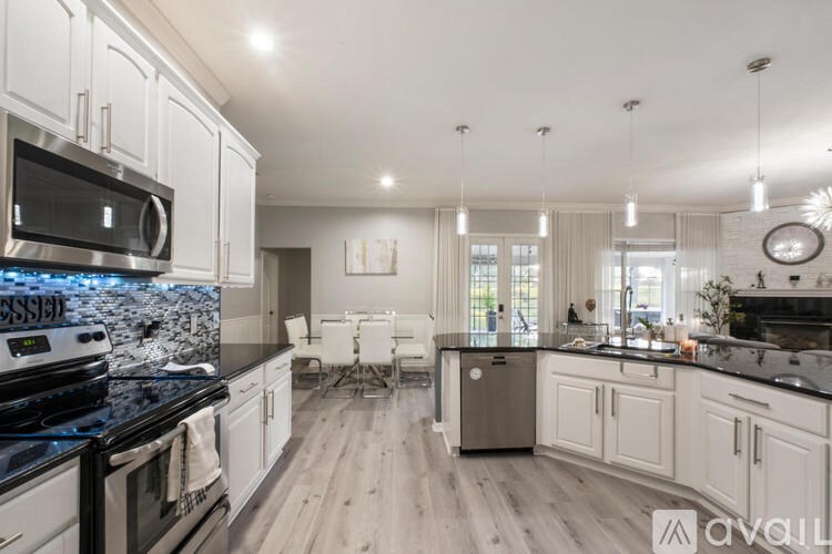 A modern kitchen with white cabinets and a black stove top.