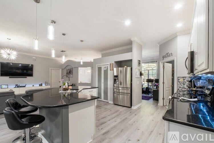 A modern kitchen with a bar area and a television.