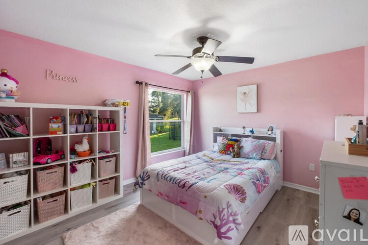 A pink bedroom with a white bed and a white dresser.