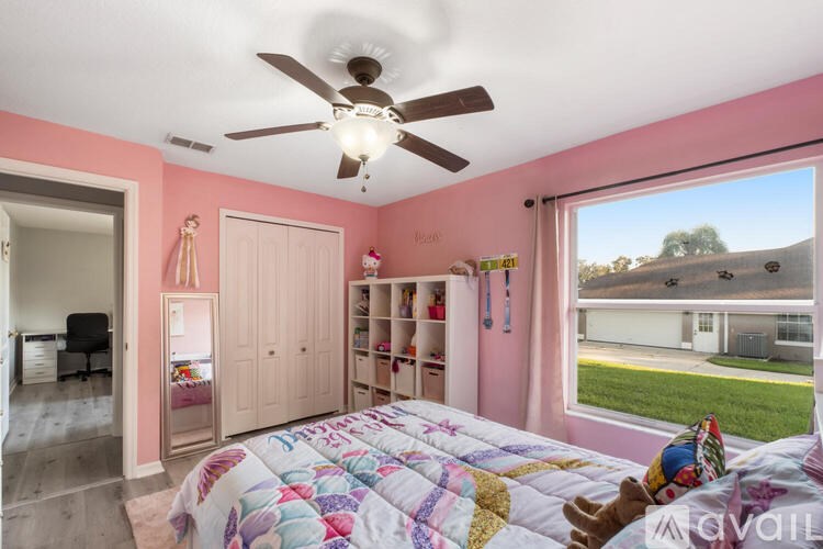 A bedroom with pink walls and a large bed.