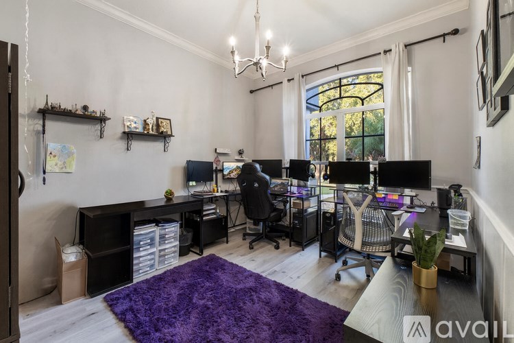 A room with a purple rug and multiple computer desks.