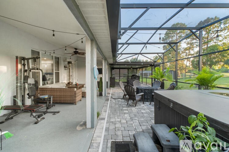 A patio area with a table and chairs under a glass roof.